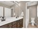 Bright bathroom featuring double sinks, vanity with dark wood cabinets, and tub shower at 5614 Bishop Flowers St, Las Vegas, NV 89130