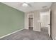 A carpeted bedroom with two-tone walls, ceiling fan, and view to closet and hallway at 5614 Bishop Flowers St, Las Vegas, NV 89130