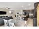 Modern kitchen with dark cabinetry, a granite-topped island with seating, and open layout to dining and living areas at 5614 Bishop Flowers St, Las Vegas, NV 89130