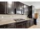 Modern kitchen features dark cabinetry, granite countertops, stainless steel appliances, and an open layout at 5614 Bishop Flowers St, Las Vegas, NV 89130