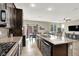 Modern kitchen with dark cabinetry, granite countertops, a gas range, and an open layout to the dining and living areas at 5614 Bishop Flowers St, Las Vegas, NV 89130