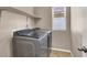 Laundry room with a washer, dryer, tile floor, shelf, and window at 5614 Bishop Flowers St, Las Vegas, NV 89130