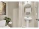 Stylish powder room with a pedestal sink, oval mirror, and neutral decor at 5614 Bishop Flowers St, Las Vegas, NV 89130