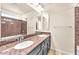 Bathroom featuring double sinks, granite countertops, and decorative tiled shower with neutral paint at 5671 Camilla Cellars Ct, Las Vegas, NV 89141