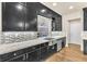 Elegant kitchen featuring black cabinets, granite countertops, and stainless steel sink and appliances at 5671 Camilla Cellars Ct, Las Vegas, NV 89141
