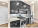 Modern kitchen with stainless steel appliances, granite counters, and dark cabinets at 5671 Camilla Cellars Ct, Las Vegas, NV 89141