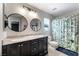 Bright bathroom with double sinks, framed mirrors, and a decorative shower curtain at 6745 Jackson Junction St, Las Vegas, NV 89149