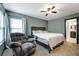 Carpeted main bedroom with a ceiling fan, window with curtains, and a comfortable chair at 6745 Jackson Junction St, Las Vegas, NV 89149