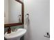 Comfortable powder room featuring a pedestal sink, mirror, and convenient towel rack at 6745 Jackson Junction St, Las Vegas, NV 89149