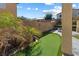 This backyard features an artificial putting green, palm trees, rock landscaping, and a brick wall at 6909 Forest Gate St, North Las Vegas, NV 89084