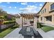This backyard has a partially covered patio, outdoor kitchen, firepit, artificial turf, and mature trees at 6909 Forest Gate St, North Las Vegas, NV 89084