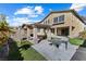 This backyard has a partially covered patio, outdoor kitchen, firepit, artificial turf, and mature trees at 6909 Forest Gate St, North Las Vegas, NV 89084