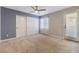 Neutral-toned bedroom featuring a ceiling fan, a pair of double-door closets, and natural light at 6909 Forest Gate St, North Las Vegas, NV 89084