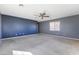 Large carpeted bedroom features a ceiling fan, window with blinds and outlets along the blue wall at 6909 Forest Gate St, North Las Vegas, NV 89084