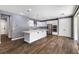 Open concept kitchen featuring a center island, stainless steel appliances, and wood floors at 6909 Forest Gate St, North Las Vegas, NV 89084