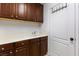 Functional laundry room with wood cabinets, a white countertop, and a sink at 6909 Forest Gate St, North Las Vegas, NV 89084