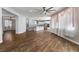 Open-concept living room leading to kitchen with stainless steel appliances, wood floors, and natural light at 6909 Forest Gate St, North Las Vegas, NV 89084