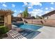 Backyard swimming pool with pergola, stone wall, and manicured landscaping at 6909 Forest Gate St, North Las Vegas, NV 89084
