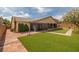 Wide shot of beautiful backyard that has artificial turf, desert landscaping and a built-in barbeque at 7180 White Bloom Ave, Las Vegas, NV 89117