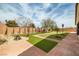 Gorgeous backyard with green turf and desert landscaping with a firepit feature at 7180 White Bloom Ave, Las Vegas, NV 89117