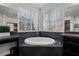 Luxurious primary bathroom features a soaking tub with tiled surround and plantation shutters at 7180 White Bloom Ave, Las Vegas, NV 89117