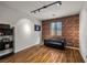 Well-lit room with faux brick wall, modern lighting, sleek hardwood floors, and comfortable seating at 7180 White Bloom Ave, Las Vegas, NV 89117