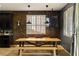 Bright dining area with a rustic wood table, modern lighting, and large window at 7180 White Bloom Ave, Las Vegas, NV 89117
