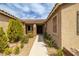 Inviting front entry showcasing a covered porch, stone accents, and lush landscaping at 7180 White Bloom Ave, Las Vegas, NV 89117
