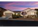 Attractive single-story home at dusk with a low-maintenance desert landscape and two car garage at 7180 White Bloom Ave, Las Vegas, NV 89117
