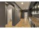 Hallway with access to bathroom, wood door, and kitchen with granite countertops at 7180 White Bloom Ave, Las Vegas, NV 89117