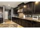 Stylish kitchen with dark wood cabinets, granite countertops, and stainless steel hood vent at 7180 White Bloom Ave, Las Vegas, NV 89117
