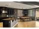 Gourmet kitchen with dark cabinetry, granite countertops, stainless steel appliances, and adjacent breakfast nook at 7180 White Bloom Ave, Las Vegas, NV 89117