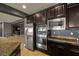 Modern kitchen with stainless steel appliances, granite countertops, and dark wood cabinets at 7180 White Bloom Ave, Las Vegas, NV 89117