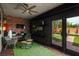 Inviting covered patio with brick accent wall, ceiling fan, and a view of the yard at 7180 White Bloom Ave, Las Vegas, NV 89117