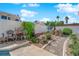 Backyard features a lush garden with seating, decorative gravel paths, palm trees, and privacy walls for a serene outdoor experience at 7405 Blue Sage Ct, Las Vegas, NV 89129