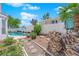 Spacious backyard with a swimming pool, lush greenery, stepping stone pathway, and privacy fence offers a serene retreat at 7405 Blue Sage Ct, Las Vegas, NV 89129