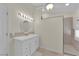 Bright bathroom featuring a white vanity with a sink and a separate shower area at 7405 Blue Sage Ct, Las Vegas, NV 89129