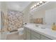 Traditional bathroom with floral shower curtain, white tiled counter and toilet at 7405 Blue Sage Ct, Las Vegas, NV 89129