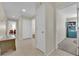 Hallway featuring access to multiple rooms with tiled flooring and neutral paint at 7405 Blue Sage Ct, Las Vegas, NV 89129