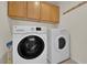 Convenient laundry room featuring a washer, dryer, and upper cabinets at 7405 Blue Sage Ct, Las Vegas, NV 89129