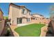 A well-maintained backyard features lush, green grass and a stylish two-story home at 7826 Shingle Beach St, Las Vegas, NV 89166