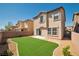 A well-maintained backyard features lush, green grass and a stylish two-story home at 7826 Shingle Beach St, Las Vegas, NV 89166