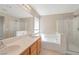 A bathroom featuring dual sinks, a separate shower, and a soaking tub at 7826 Shingle Beach St, Las Vegas, NV 89166