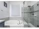 Modern bathroom features a tub with chrome faucet, and a glass-enclosed shower with a rain shower head at 792 Valley Rise Dr, Henderson, NV 89052