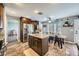 Well-lit kitchen with stainless steel appliances, central island with granite countertops, and wood-look tile flooring at 8228 Fritzen Ave, Las Vegas, NV 89131