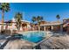 Community pool with clear water, seating areas and multiple palm trees in a desert residential area at 830 Carnegie St # 724, Henderson, NV 89052