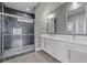 This bathroom features double sinks with white cabinets and glass shower with gray marble tile at 9090 Josepine St, Pahrump, NV 89048