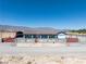 Charming single-story home with a red gate, desert landscaping, and mountain views at 9090 Josepine St, Pahrump, NV 89048