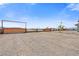 Gravel driveway with fenced entry and metal gate, set against a backdrop of desert landscape under a blue sky at 9090 Josepine St, Pahrump, NV 89048