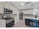 Modern kitchen featuring stainless steel appliances, gray backsplash, island with breakfast bar and white cabinets at 9090 Josepine St, Pahrump, NV 89048